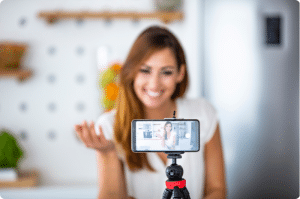 A girl filming herself on a cell phone who needs to learn about Tax Write-Offs for Social Media Influencers